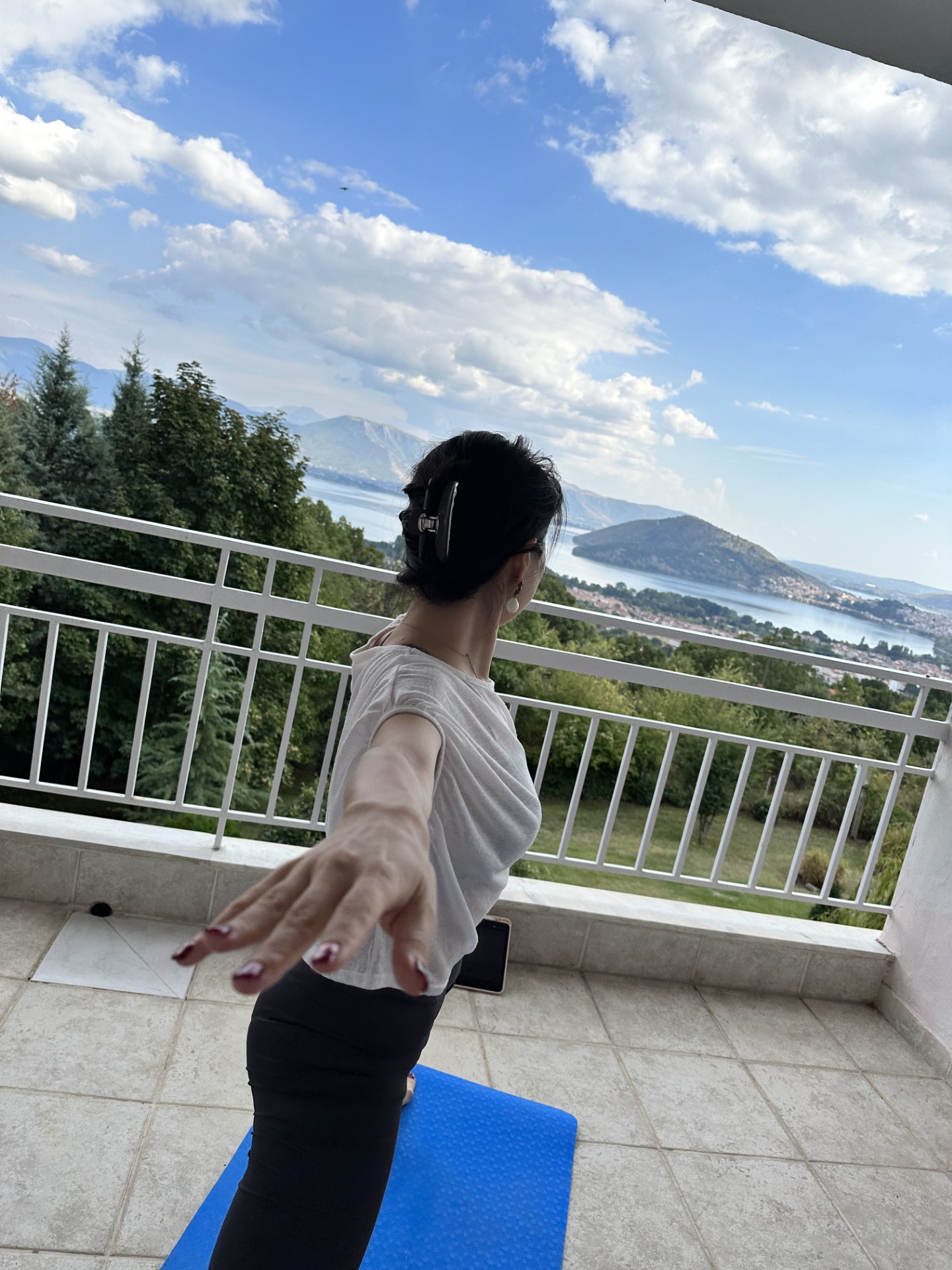 Madoka Muramatsu in a yoga pose overlooking mountains and lake
